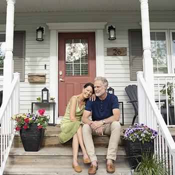 Couple sitting on front stairs of a home.