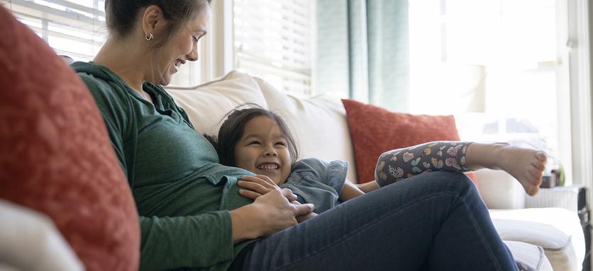 Young girl listening to pregnant mother's belly