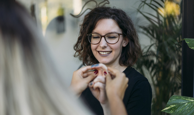 A woman with glasses getting a hand massage.