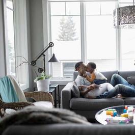 Parents playing with young kids on the couch.