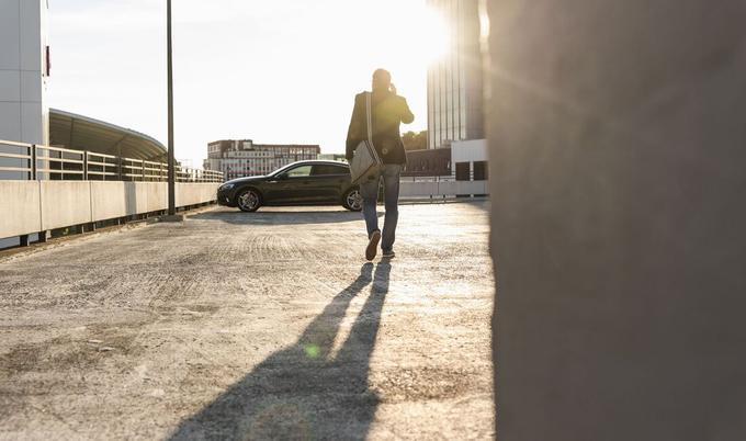 Man walking to his car in a parking lot.