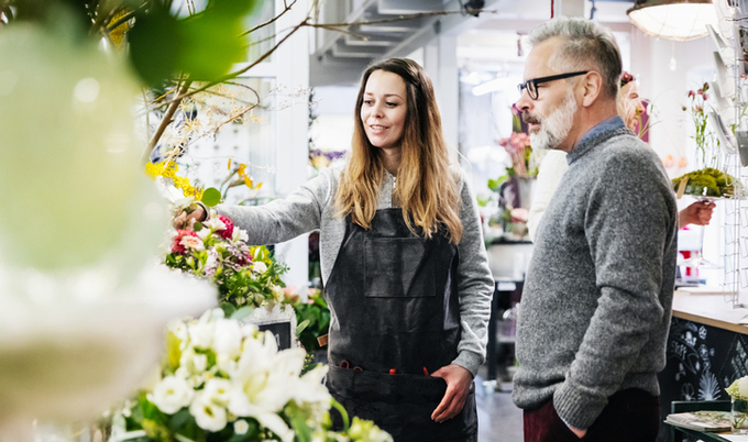 A man standing with a florist in a flower shop.