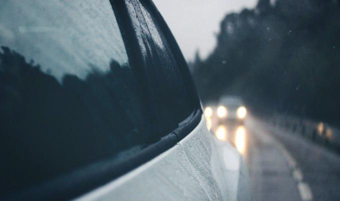 View of road through windshield on rainy day.