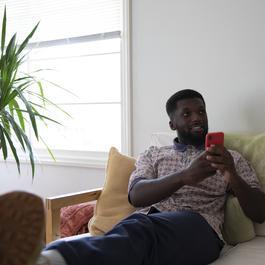man looking up from phone