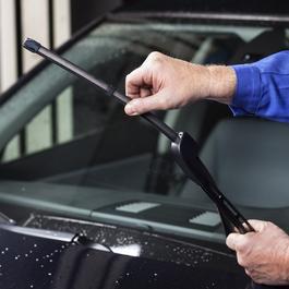 Man checking windshield wiper blade.