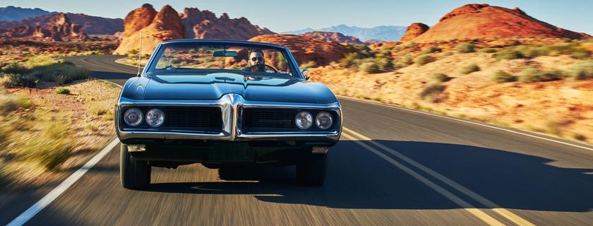 Man driving vintage car through desert