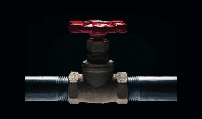 Red stop valve connecting two straight pipes.