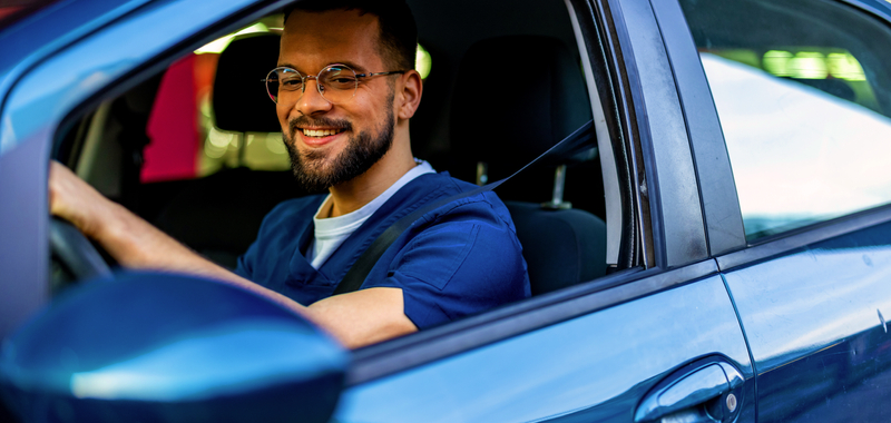 A confident male healthcare professional drives to work in a hospital.