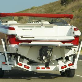 SUV hauling boat on trailer.