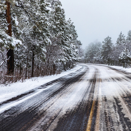 Dangerous country road covered in black ice and snow during winter