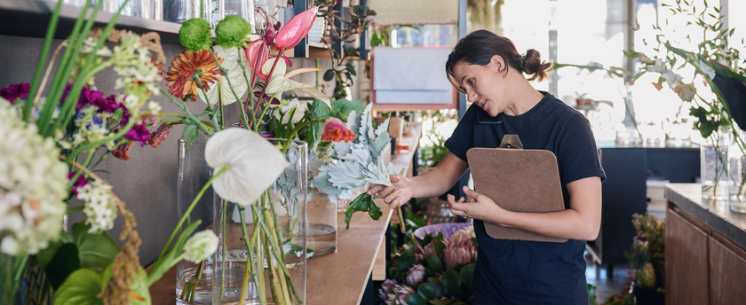 Florist standing in her flower shop talking on the phone
