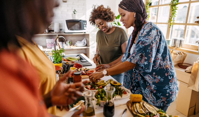 Women in a kitchen cooking together.