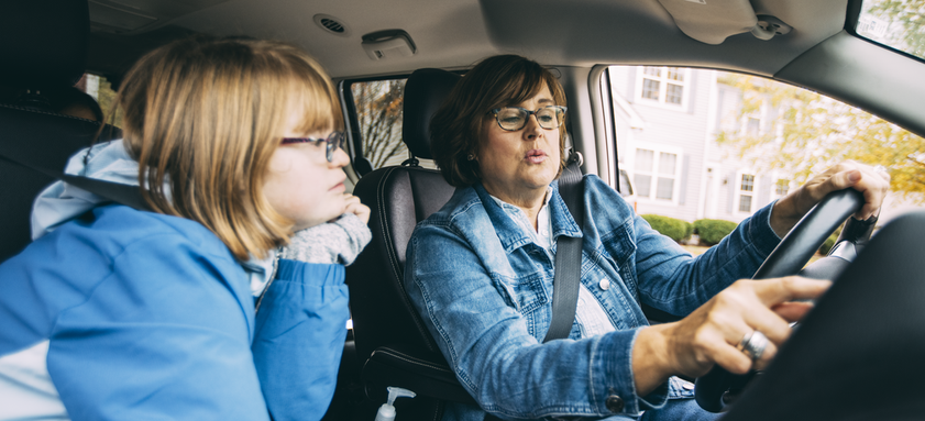 Mother and daughter looking at dashboard in car