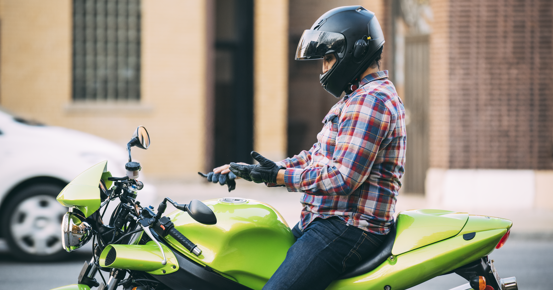 Guy on motorcycle putting gloves on