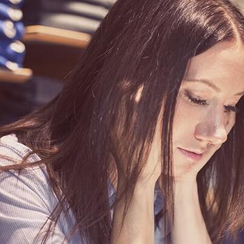 Woman's face looking down in a clothing store.