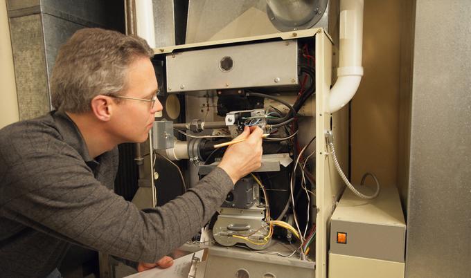 Technician inspecting home furance.