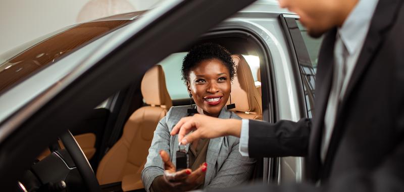 man handing woman keys to a car 