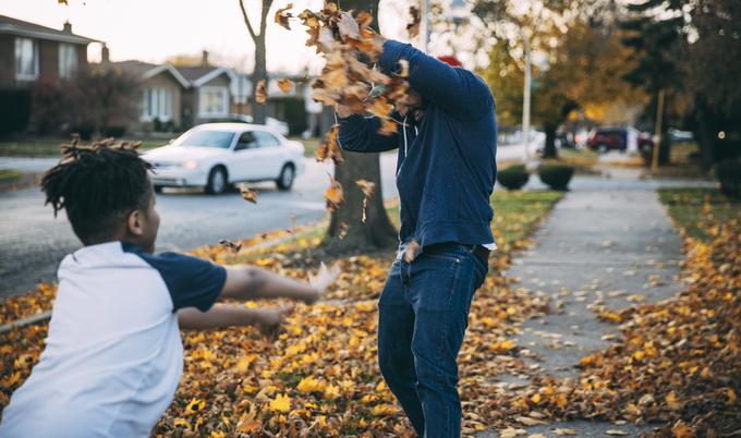 Father and son playing in leaves