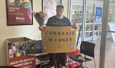 Circle K Gas Giveaway Winner standing with a congrats sign
