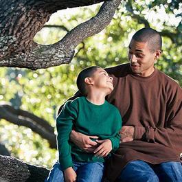 Father and son sitting on tree