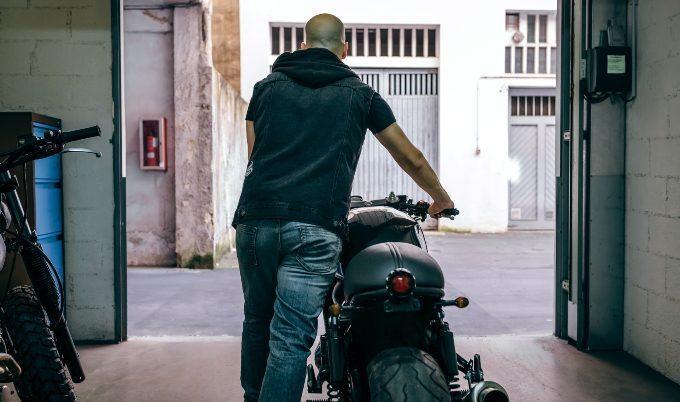 man pushing motorcycle