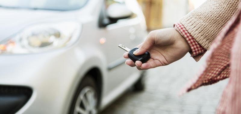 woman using car remote in front of vehicle 