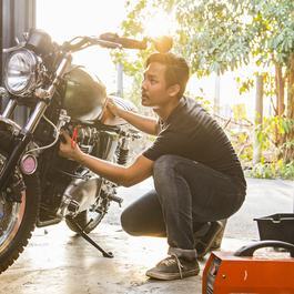 Man working on motorcycle in garage. 