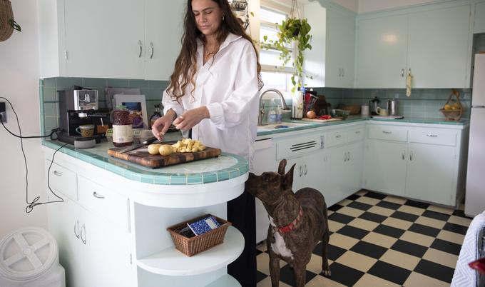 meal prep in kitchen with female and dog