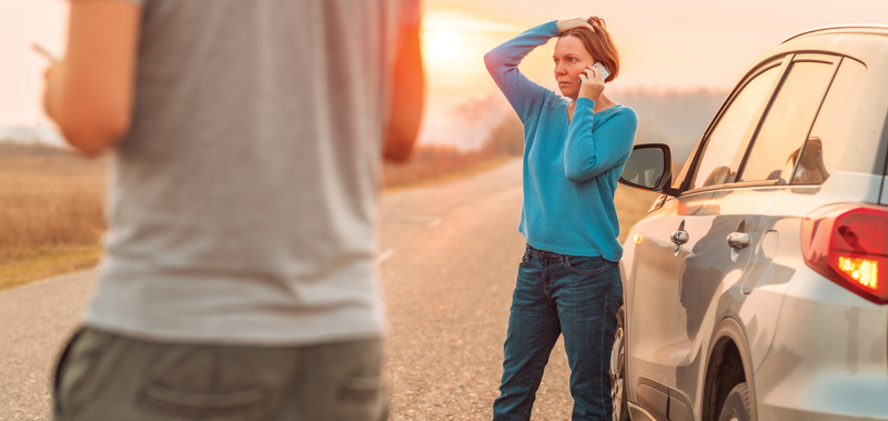 stressed woman on the side of the road after an accident 