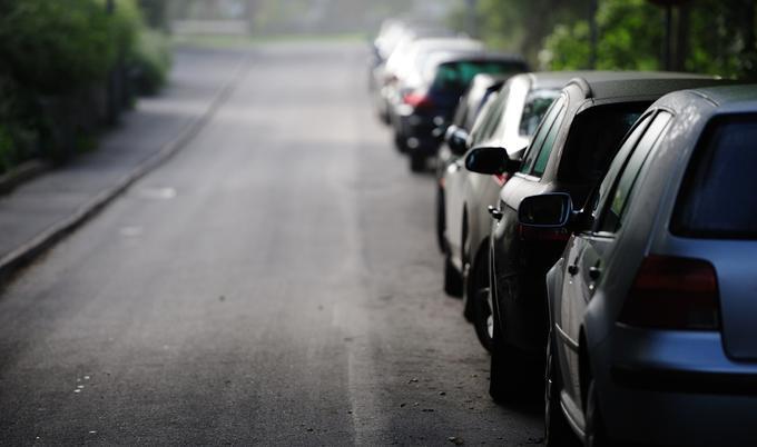 Cars are parallel parked along the side of a street.