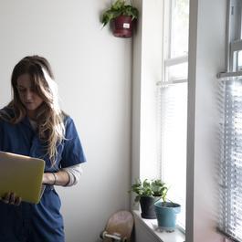 female looking at her computer while walking in home