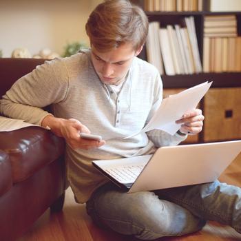 young-man-sitting-on-floor-with-paperwork-computer-gettyimages.jpg