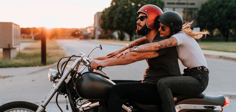 couple riding motorcycle in the sunset 