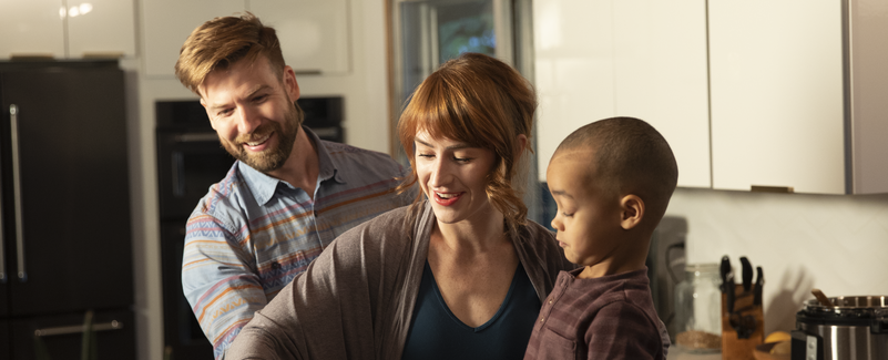 mom, dad and son preparing dinner in the kitchen