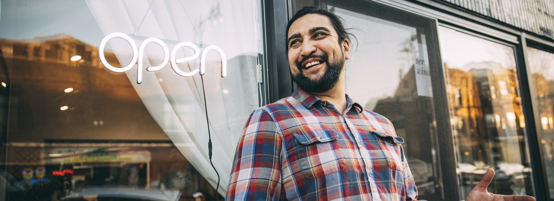 Man holding phone outside of restaurant