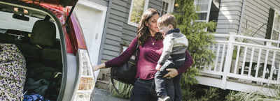Woman and son standing by car in driveway