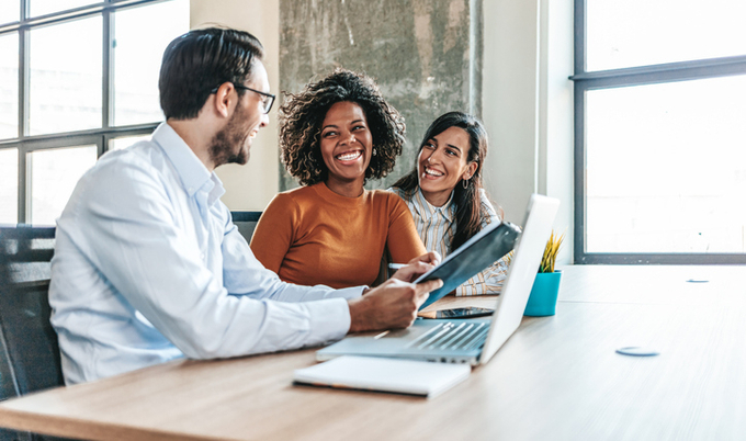 Co-workers enjoying time together in the office at a desk.