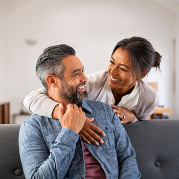 Couple smiling at each other at home.