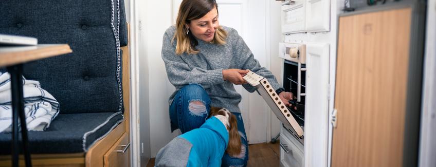 Adult woman using the oven in her manufactured home.