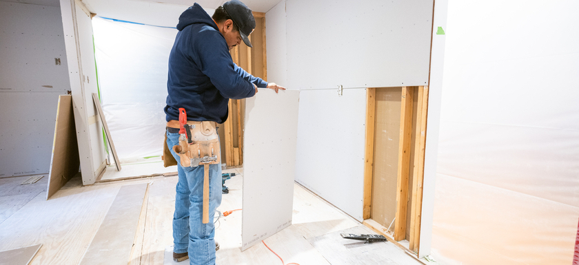 Drywall installers working in kitchen renovation