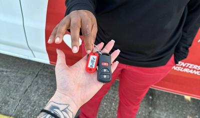 Direct Auto agent passing keys to the Dottie Van to another agent. 