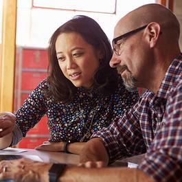 Couple looking at something on a laptop.