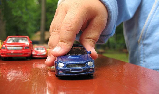 child hand playing with toy car