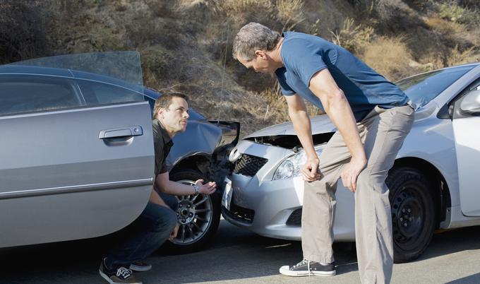 Two men at the scene of a car crash. 