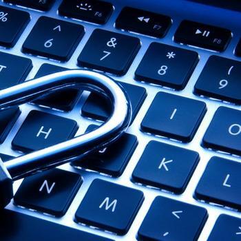 Close-up of laptop keyboard with  a lock laying on top.