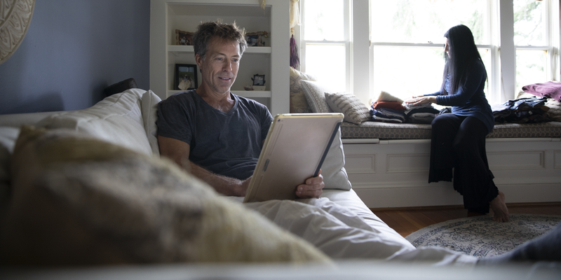 man on tablet lounging at home