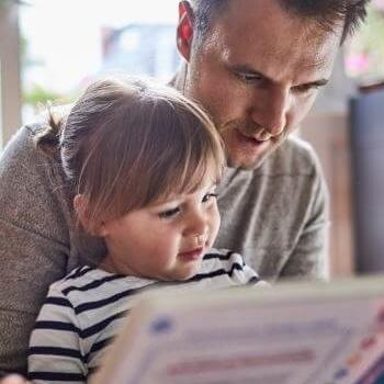 Father reading to daughter