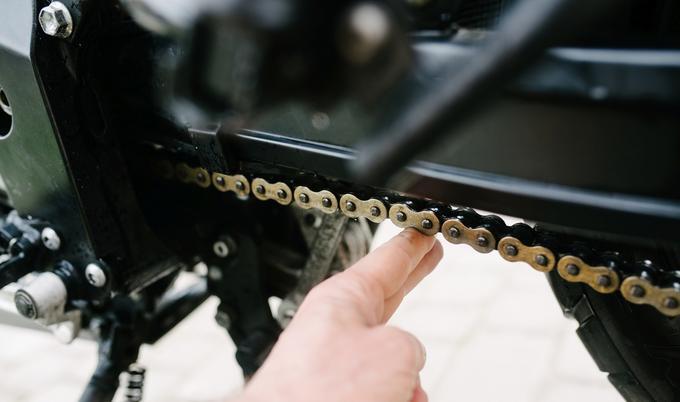 Checking motorcycle chain before riding. 