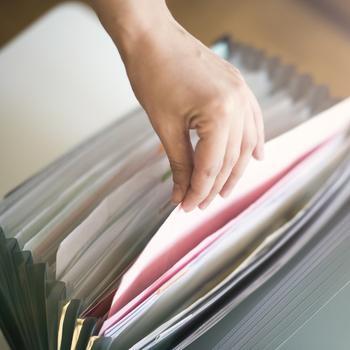 Person taking paper out of a file organizer.