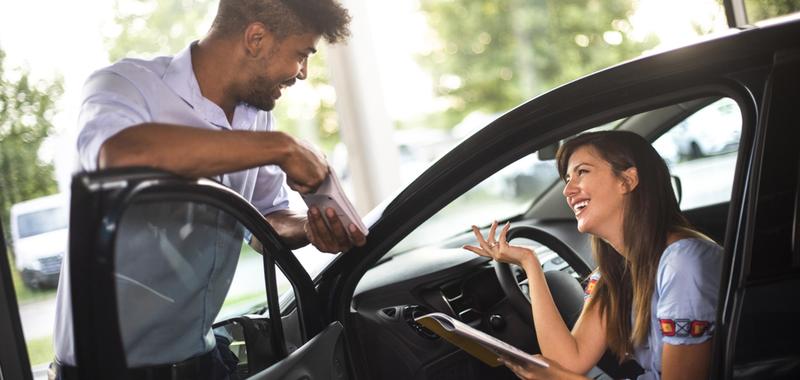 woman sitting in a vehicle discussing information with an advisor 